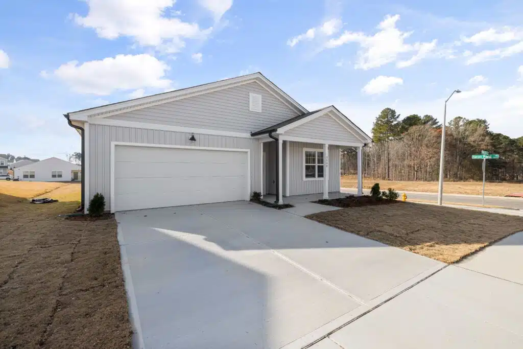 Modern single-story house with white siding and two-car garage in suburban neighborhood