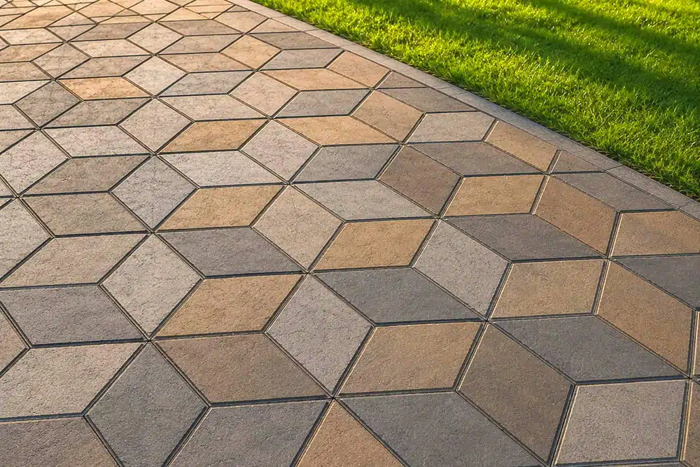 Geometric stone pathway with hexagonal pattern beside green grass lawn