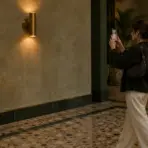 Woman taking photo in elegant hotel lobby with marble flooring and warm lighting