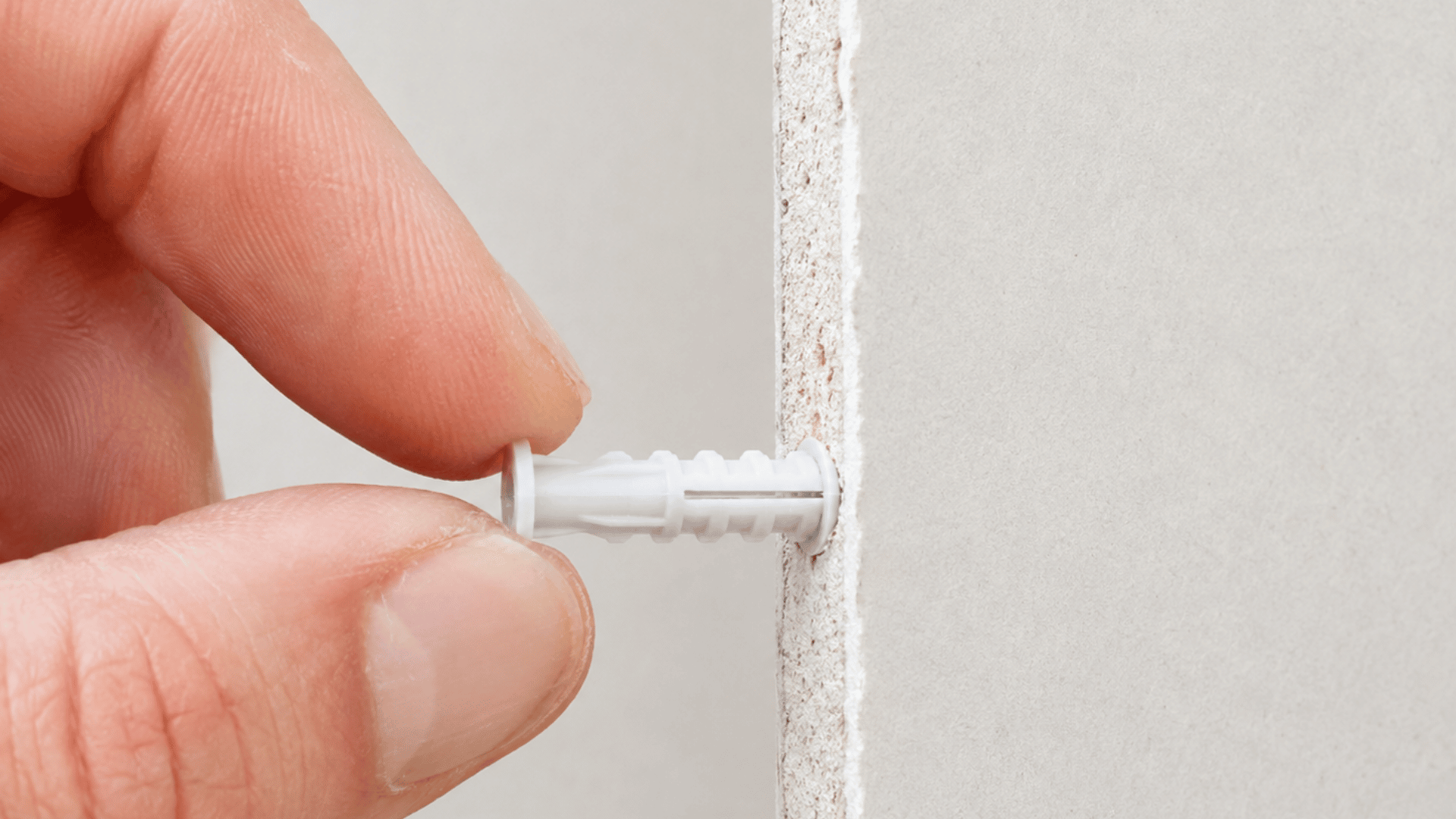 view of a drywall anchor inserted into drywall with the flange sitting flush against the surface