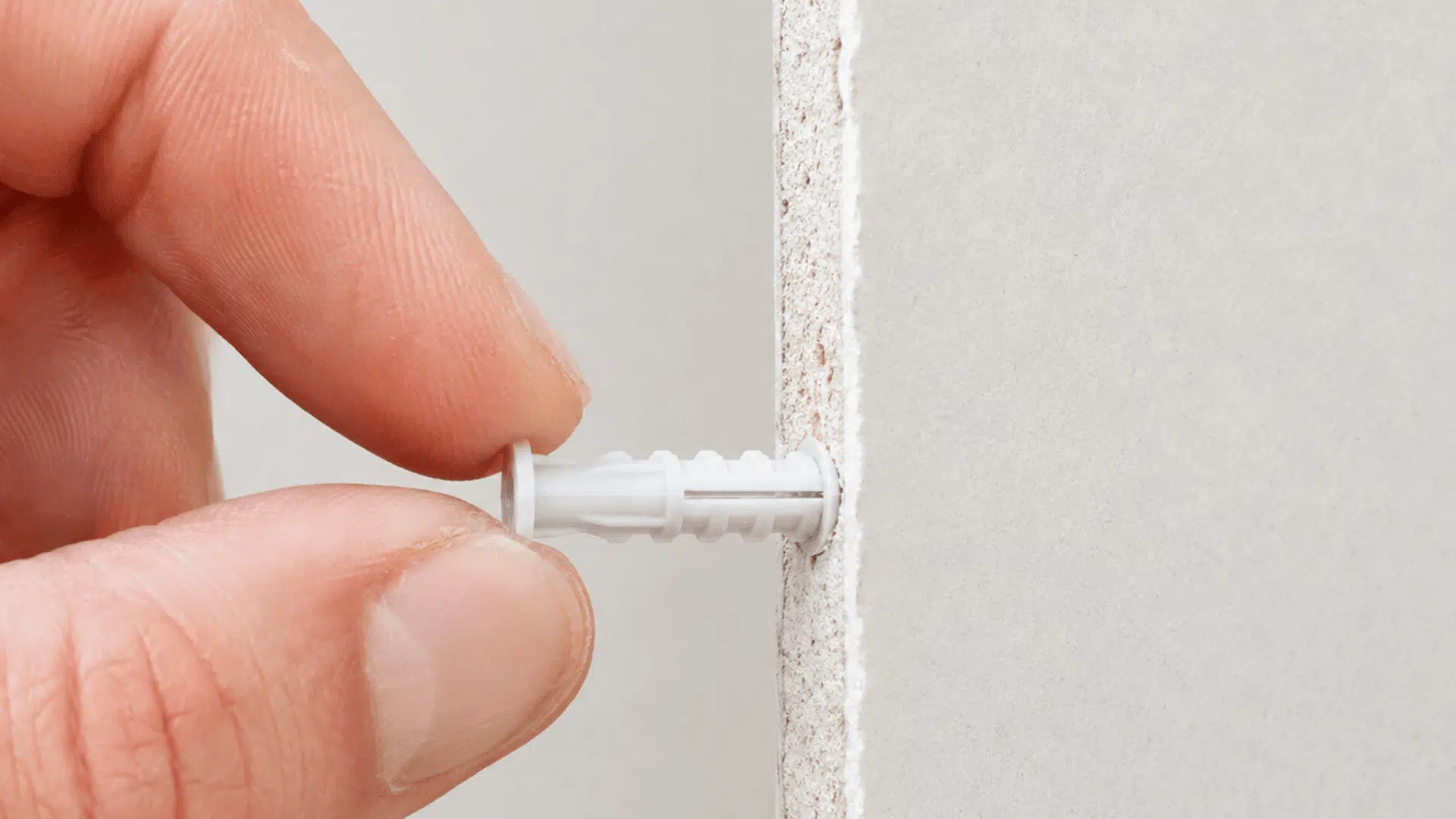 view of a drywall anchor inserted into drywall with the flange sitting flush against the surface