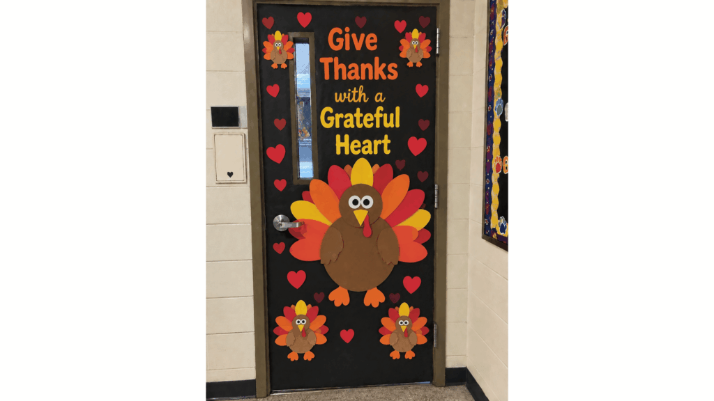 fall classroom door with a paper tree, colorful leaves, and "Fall in Love with Learning" letters
