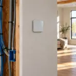 Wiring and conduits in a partially constructed room with view of modern living space