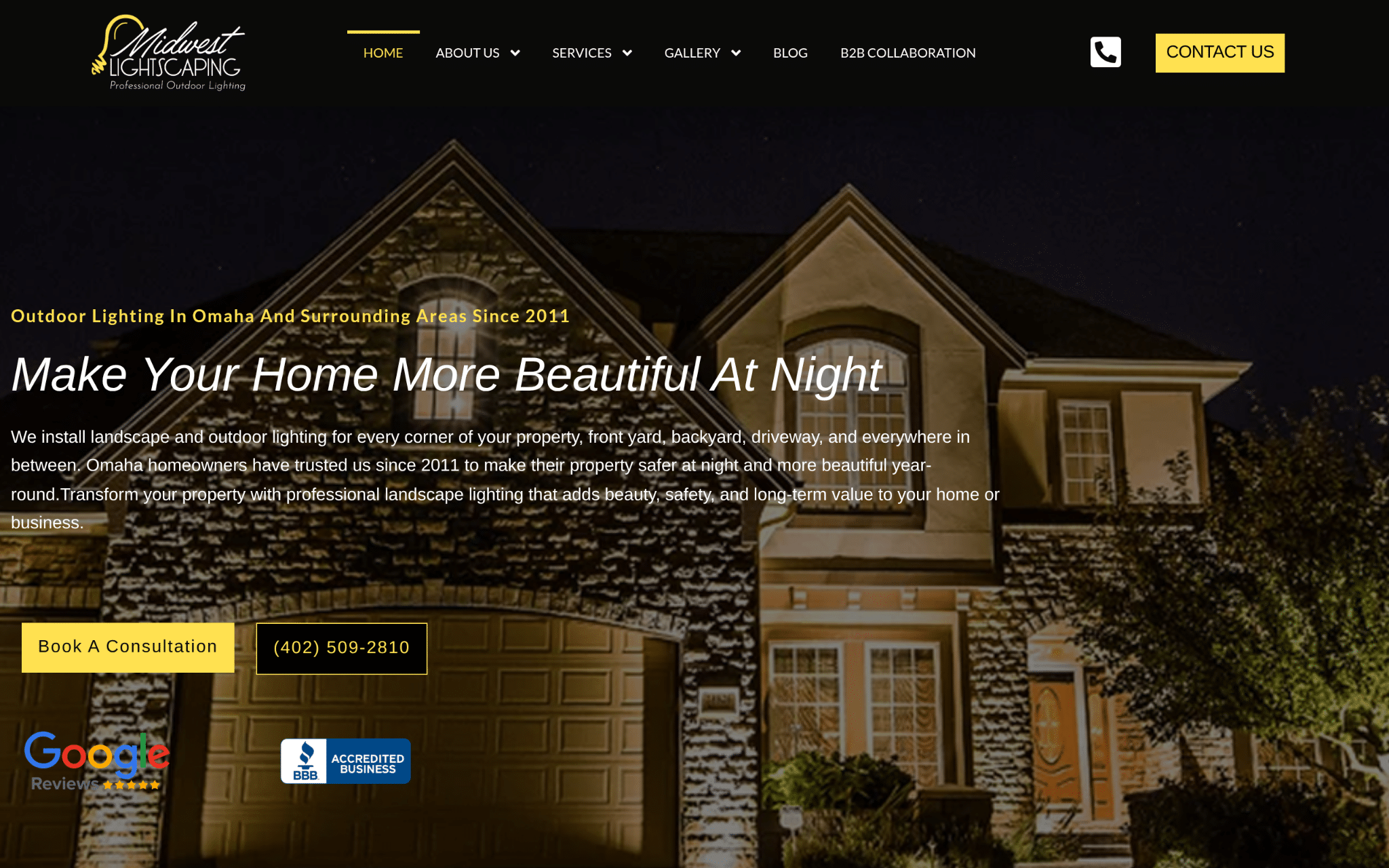House with illuminated exterior lighting at night highlighting stone facade and arched windows