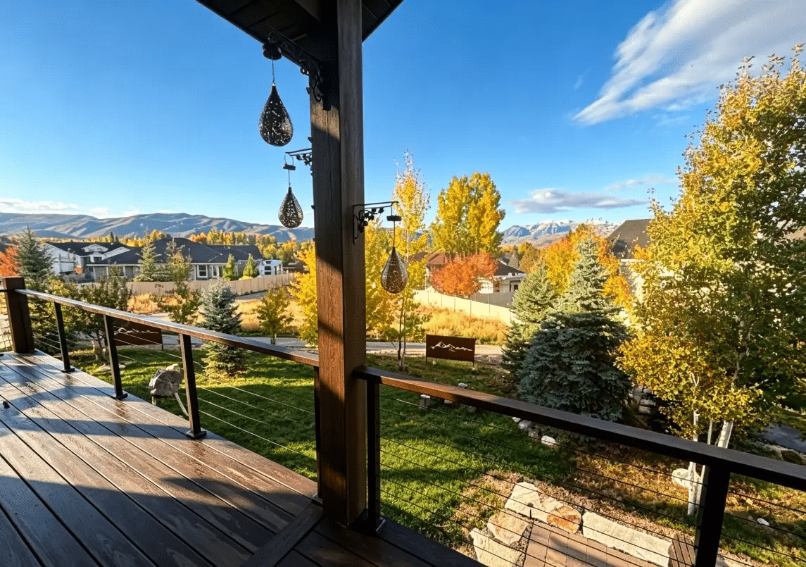 Wooden deck overlooking colorful autumn landscape with mountains in the distance under clear blue sky