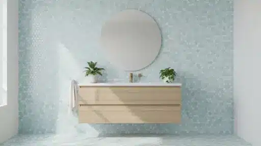 Modern bathroom with round mirror above floating wood vanity, blue hexagonal tile wall, and leafy plants