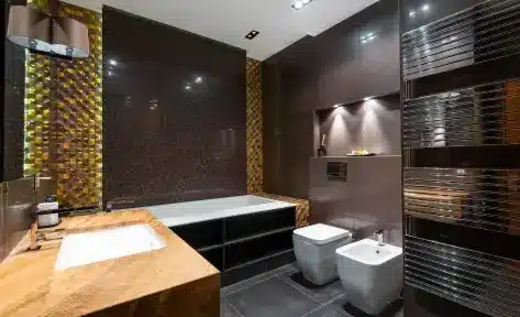 Modern bathroom with wood countertop, tub, and dark tiled walls under warm lighting