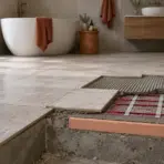 Bathroom under renovation with exposed floor heating elements and unlaid tiles in modern setting